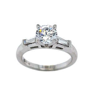 Diamond engagement ring with channel set baguette diamond melee and a 4 prong peg head 