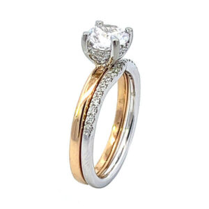 Yellow gold solitaire engagement ring with .06ct tw of brilliant cut diamond melee in the hidden halo and a white gold matching diamond wedding band set with .12ct tw of brilliant cut diamond melee 