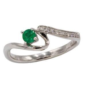 Round cut emerald ring with channel set diamonds in a white gold freeform setting